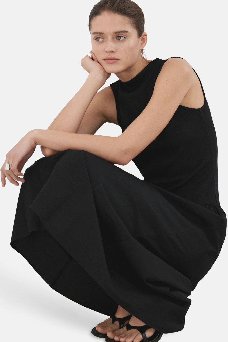 Robe noire sans manches de MANGO, avec un style minimaliste et des sandales visibles.