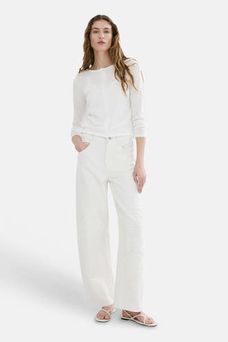 Jean en denim blanc cassé CAMERON de MANGO, avec des motifs floraux brodés ton sur ton sur les jambes larges.