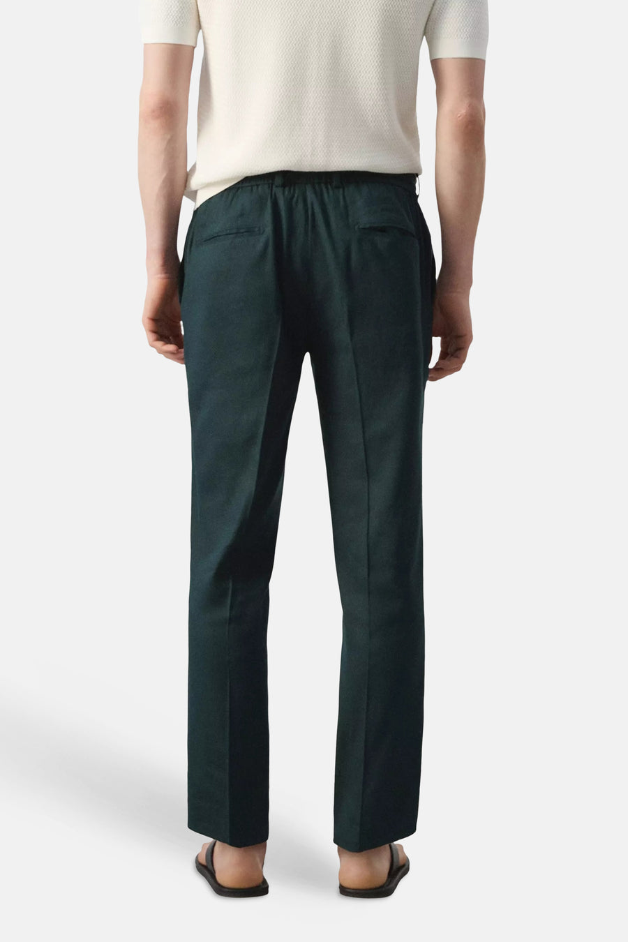 Donkergroene broek van MANGO met elastische tailleband en achterzakken, achterzicht op een man.