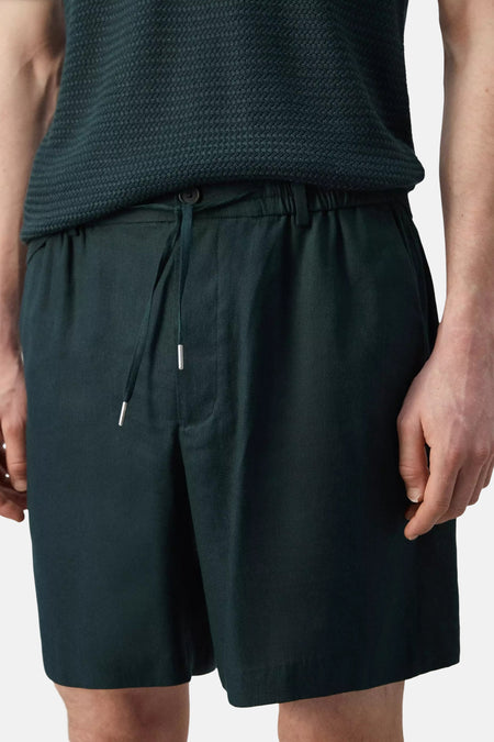 Groene Bermuda's van MANGO met elastische taille en trekkoord, lichte stof, frontzak, model in lifestyle shot