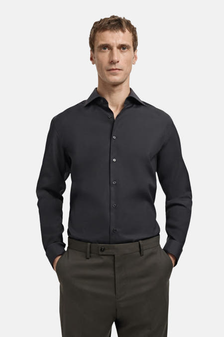 Chemise noire à manches longues de MANGO, vue de dos, associée à un pantalon foncé.