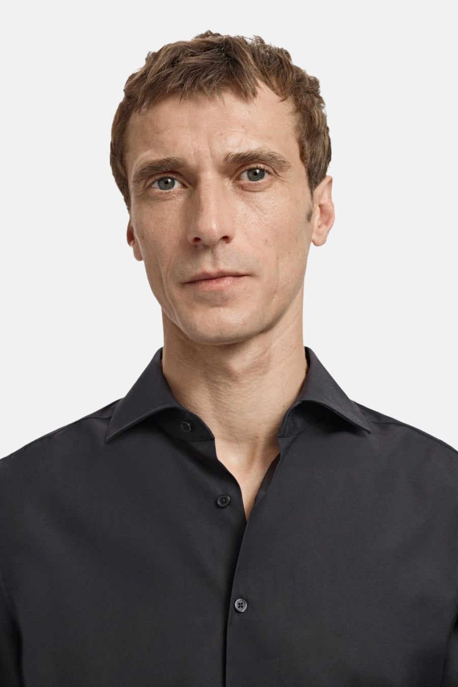 Man in zwart overhemd met knopen.
