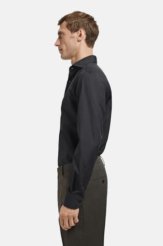 Chemise noire à manches longues de MANGO, vue de côté avec un pantalon kaki.