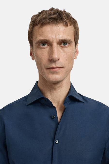 Man in blauw overhemd met knopen.
