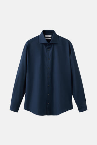 Chemise bleue à manches longues de MANGO, avec col classique et fermeture à boutons.