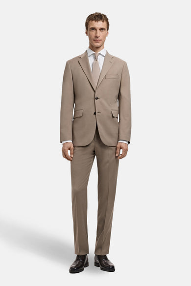 Chemise blanche à manches longues de MANGO, portée sous un manteau brun avec une cravate beige.