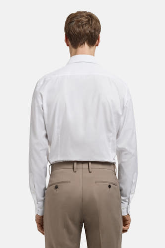 Wit overhemd met lange mouwen van MANGO, gezien van achteren, gecombineerd met een bruine pantalon.

