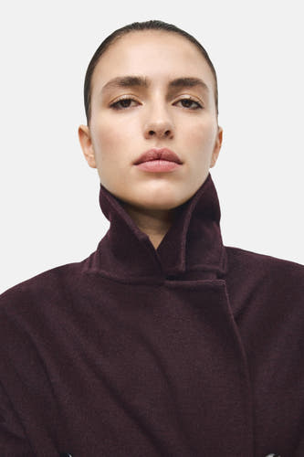 Long manteau rouge de MANGO, avec un col haut et une texture lisse et uniforme.