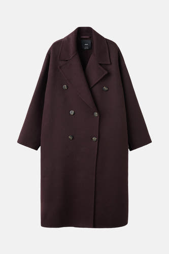 Manteau rouge long de MANGO, avec une double rangée de boutons et un col large.