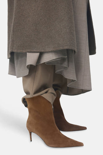 Bottines en pointe de MANGO, associées à un pantalon beige et une jupe plissée dans des tons neutres.