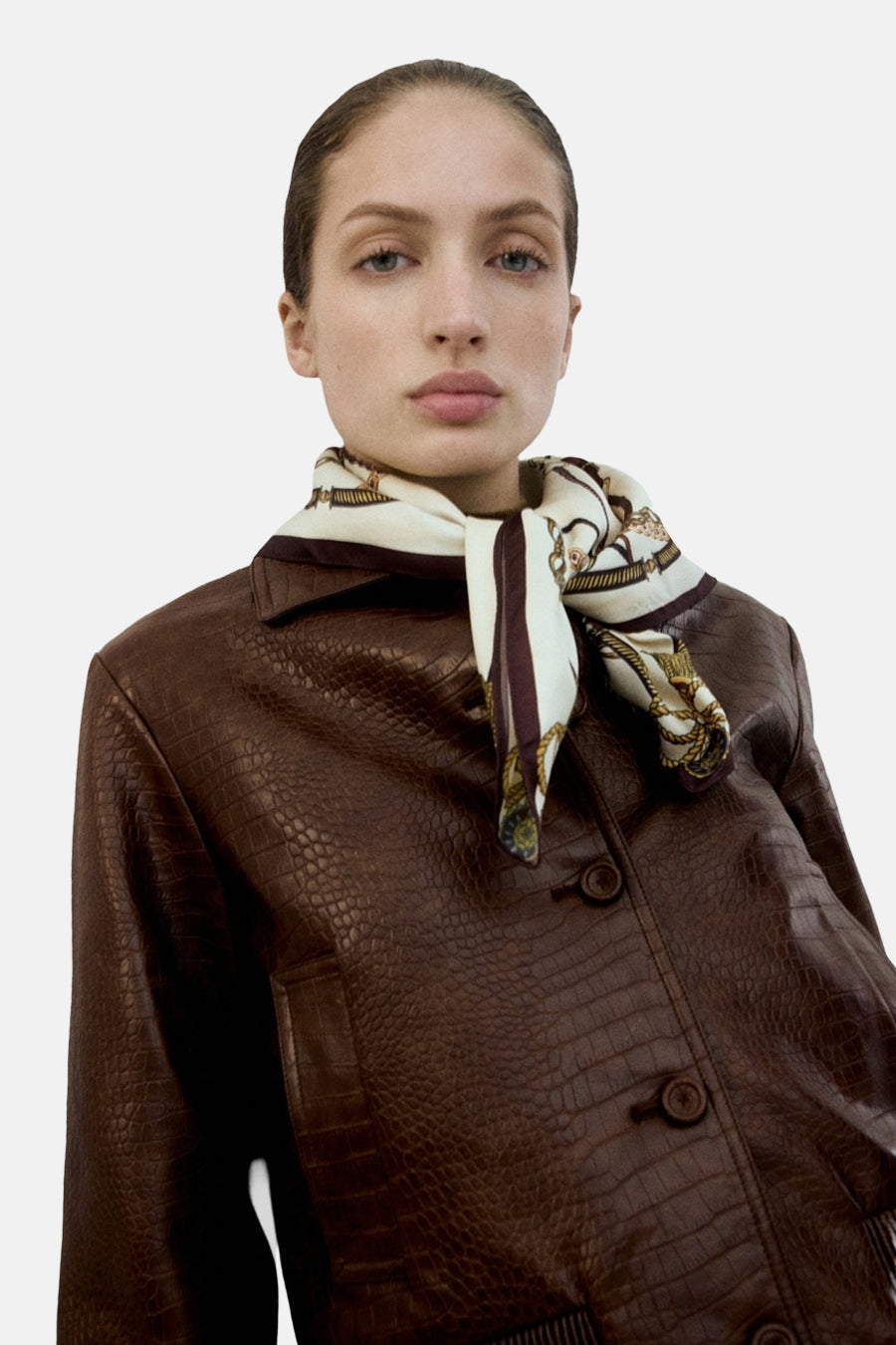 Manteau court marron de Mango, avec imprimé crocodile et une écharpe dans le col.
