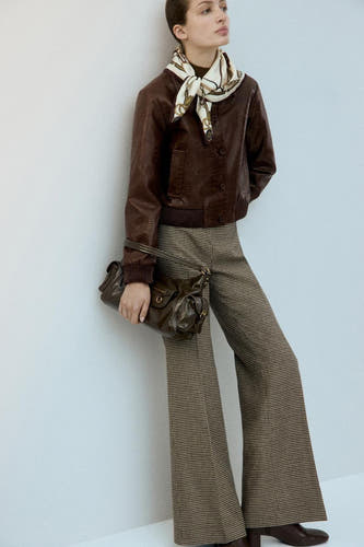 Veste courte marron de MANGO, avec un imprimé crocodile et portée avec une écharpe et un sac à main marron.