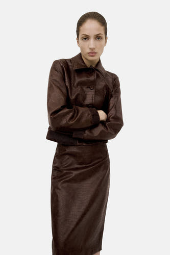 Veste courte marron de MANGO, à motif crocodile, assortie à une jupe assortie.