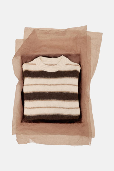 Gestreept gebreide trui, bruin en beige, verpakt in bruin papier.
