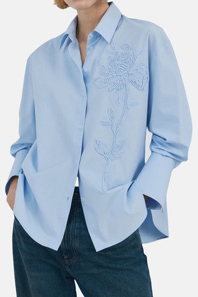 Chemise bleue à manches longues de MANGO, vue de dos, combinée avec un jean ample.
