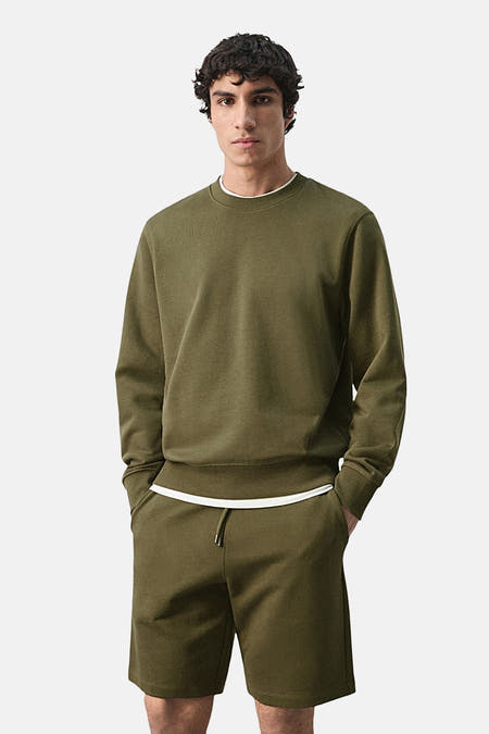 Pull col rond kaki de MANGO, vue arrière avec short assorti.