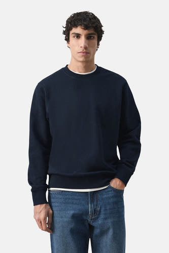 Pull noir de MANGO, vu de dos, combiné avec un jean.