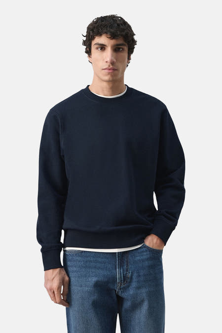 Pull noir de MANGO, vu de dos, combiné avec un jean.