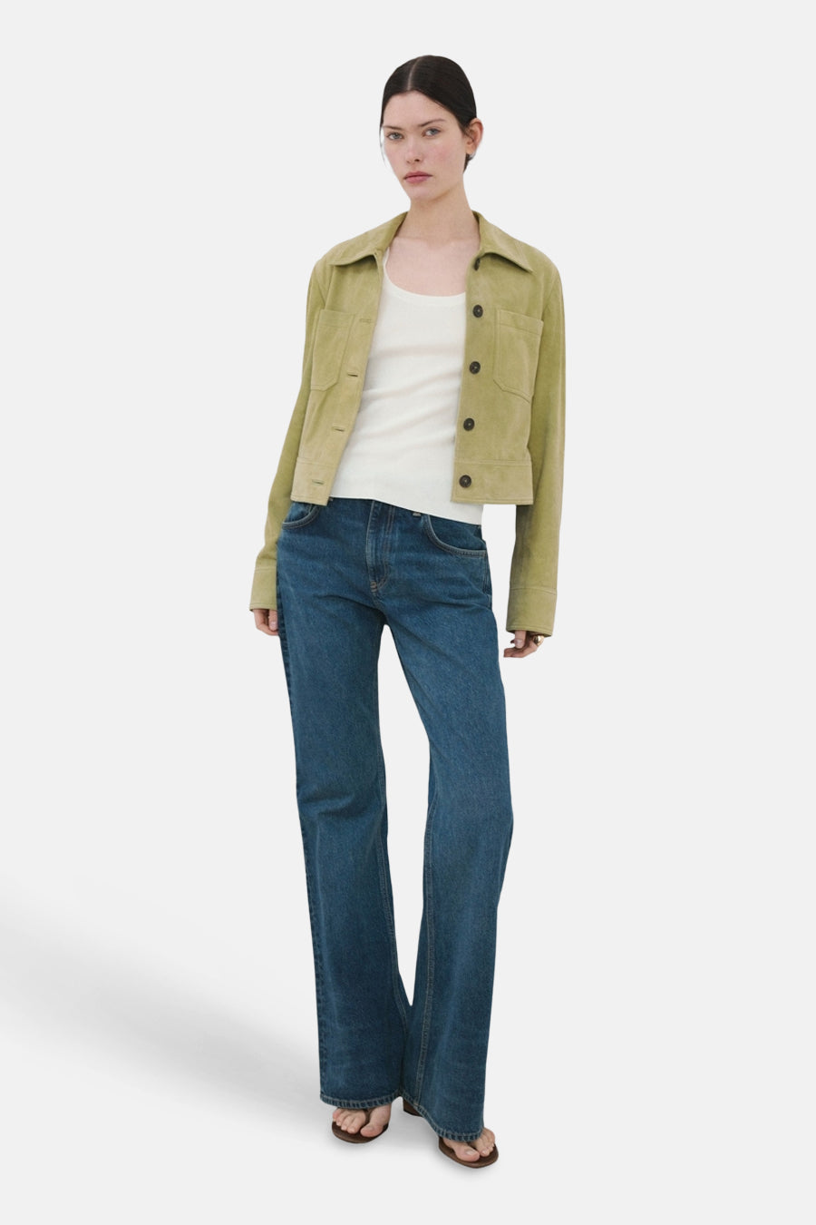 Débardeur blanc de MANGO, porté sous une veste kaki et un jean ample.