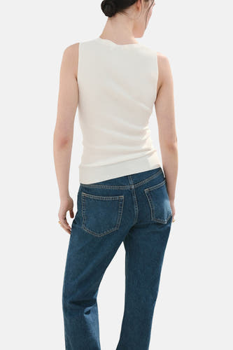 Witte top van MANGO, gezien van achteren, gedragen met een donkere jeans.