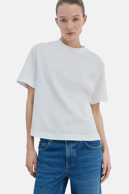 T-shirt blanc de MANGO, à manches courtes et coupe droite, vu de dos, associé à un jean bleu.
