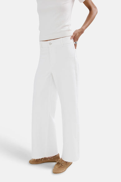 Jean large blanc de MANGO, vu de dos, associé à un t-shirt de couleur crème et des mocassins marron.