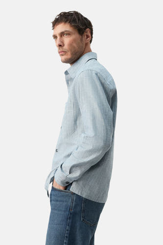Chemise bleue à manches longues de MANGO, rayée et avec une poche poitrine, vue de côté.