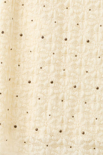 Jupe longue écru de MANGO avec un motif en dentelle et des clous bronze.