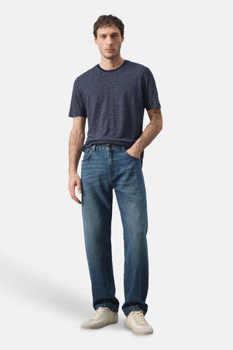 T-shirt bleu à manches courtes de MANGO, à motif rayé, porté avec un jean et des baskets.