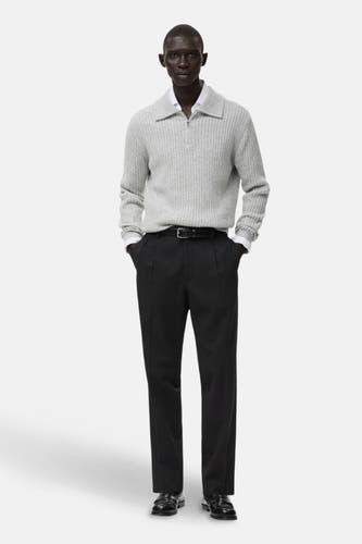 Pantalon noir de MANGO, associé à une chemise grisonnée, un blazer blanc et une ceinture noire avec boucle.