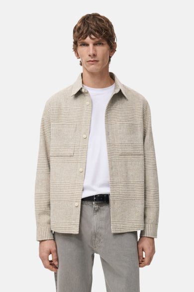 Manteau court beige de MANGO, avec un motif de fenêtre subtil et une fermeture à boutons visible sur les manches, vu de l'arrière.