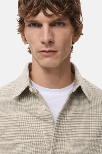 Manteau court beige de MANGO, avec un motif de fenêtre subtil et une col classique.