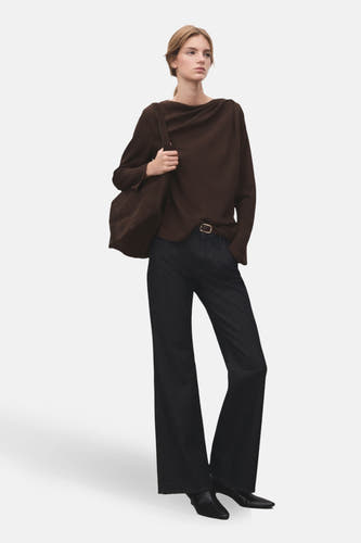 Blouse brune à longues manches de MANGO, portée avec des jeans larges et un sac à dos brun.