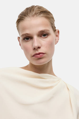Blouse écru à longues manches de MANGO, avec une encolure plissée et un tissu lisse.