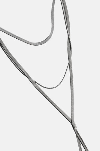 Zilverkleurige, gelaagde kettingen.
