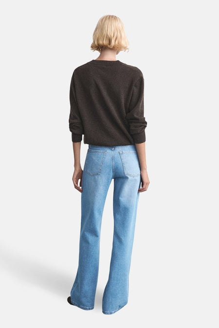 Lichtblauwe rechte jeans van MANGO, gezien van achteren, gecombineerd met een bruine trui.