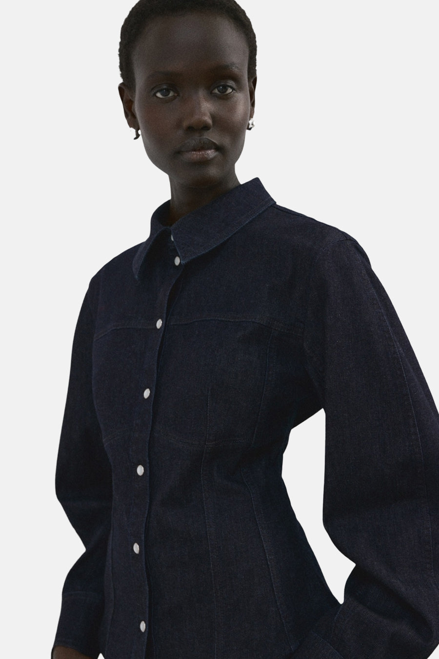 Chemise en jean bleu foncé à manches longues de MANGO, vue de dos avec un jean droit foncé.