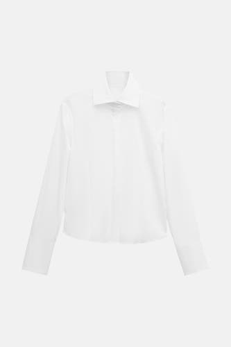 Chemise blanche à manches longues de MANGO, avec un col classique et des poignets, sur fond blanc.