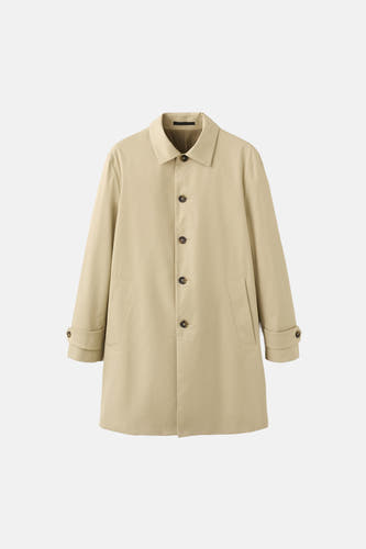 Long manteau beige de MANGO, avec étiquettes à logo et informations sur l'imperméabilité.