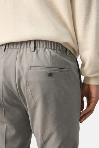 Pantalon beige de MANGO avec une taille élastique et un bouton sur la poche arrière.