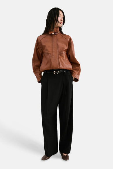 Pantalon noir de MANGO, à jambes larges et avec une ceinture noire à boucle argentée.
