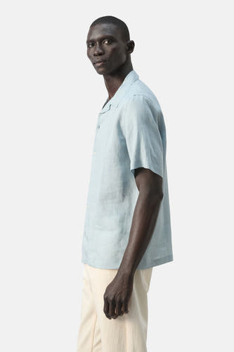 Chemise bleue à manches courtes de MANGO, unie et en mélange de lin, vue de côté.