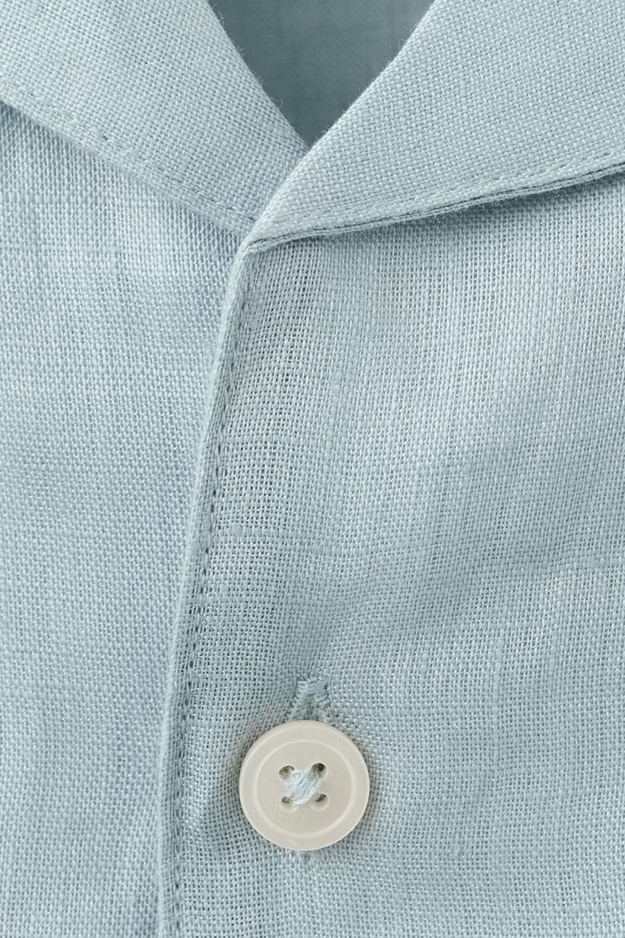 Chemise bleue à manches courtes de MANGO, avec une texture légère et un bouton unique.