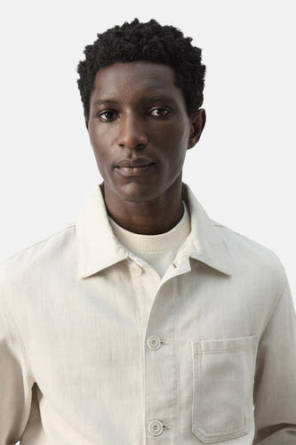 Veste courte écru de MANGO, avec manches longues et une poche poitrine plaquée.