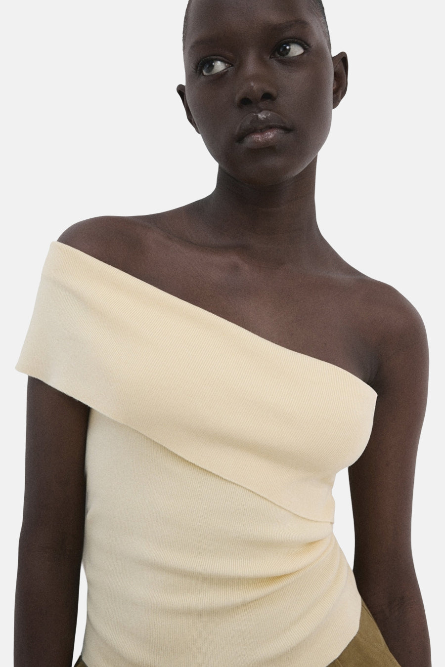 Gele T-shirt van MANGO met een gedrapeerde halslijn en ribgebreide textuur, op een model.