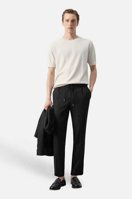 T-shirt écru à manches courtes de MANGO, côtelé et porté avec un pantalon noir.
