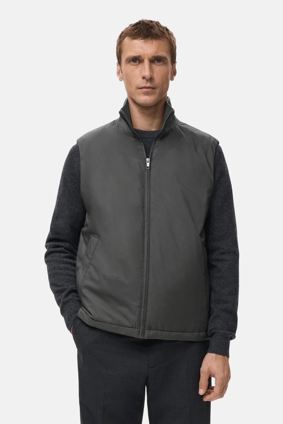 Gilet gris de MANGO, avec un col et visible porté sur une chemise et un pantalon gris foncé.