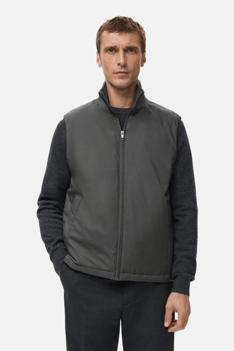 Gilet gris de MANGO, avec un col et visible porté sur une chemise et un pantalon gris foncé.