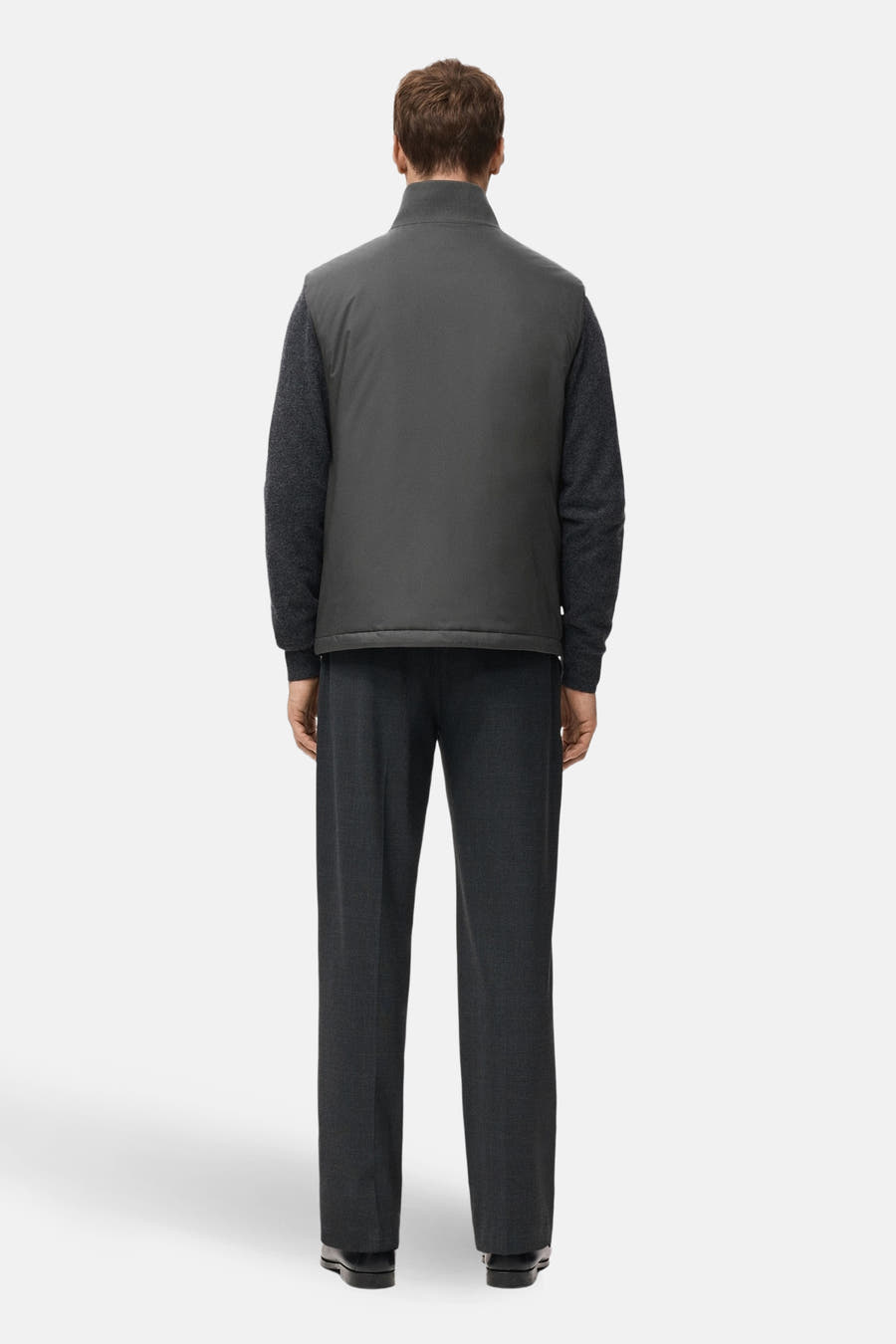 Grijs bodywarmer van MANGO, met een kraag en zichtbaar over een donkergrijze trui en pantalon gedragen.