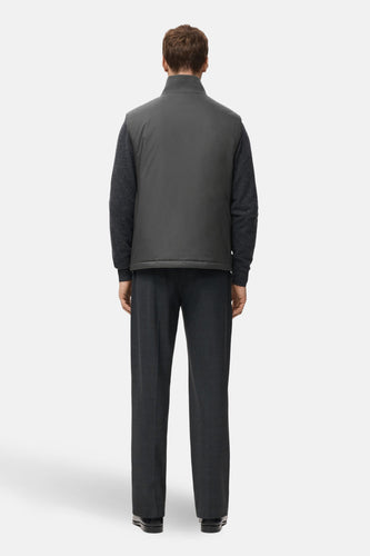 Grijs bodywarmer van MANGO, met een kraag en zichtbaar over een donkergrijze trui en pantalon gedragen.